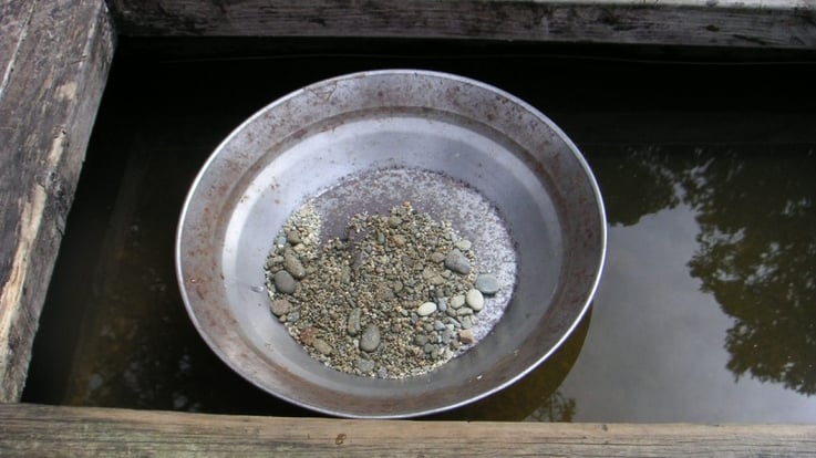 prospector's gold pan resting in water