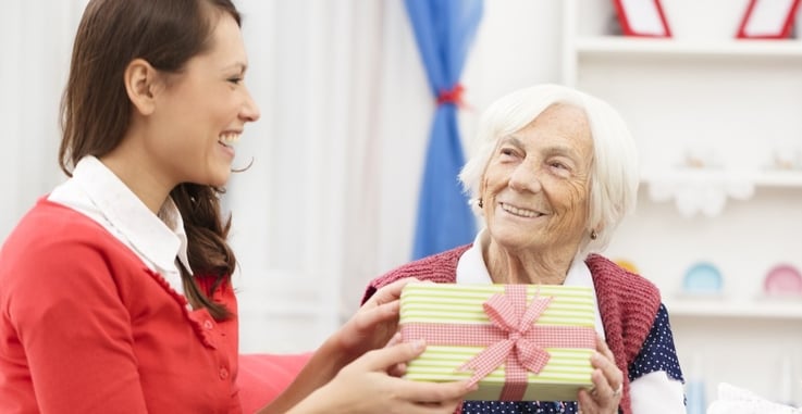 Nurse giving a Christmas gift to an assisted living resident
