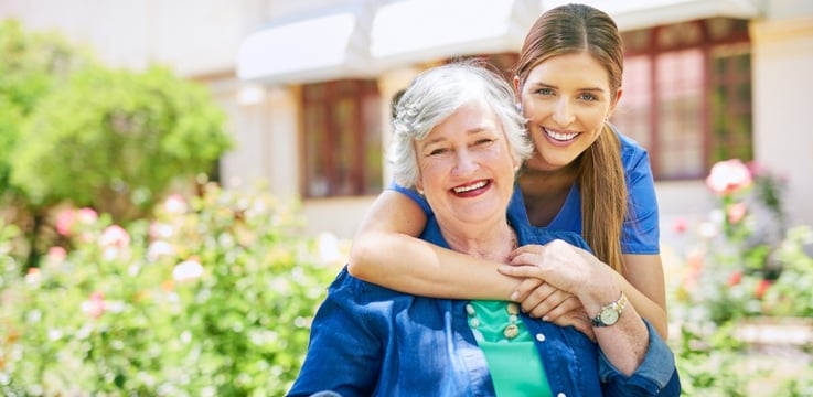 young nurse with arm around an elderly woman at a skilled nursing facility