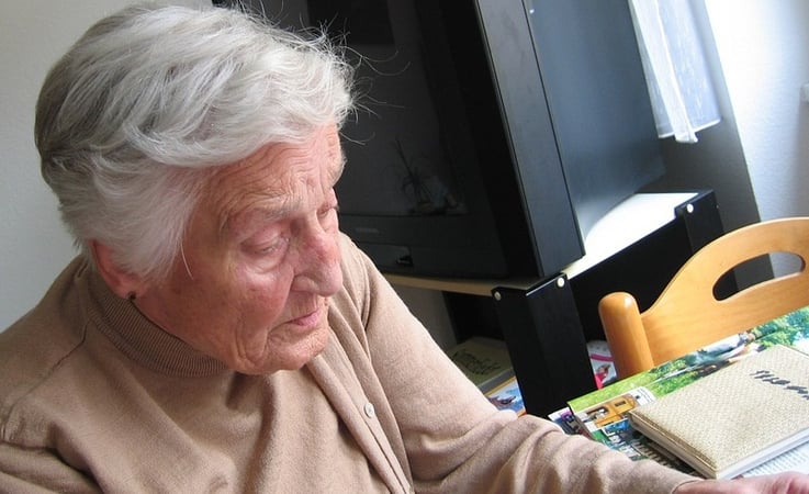 Alzheimer's resident sitting at a table looking at photos.jpg